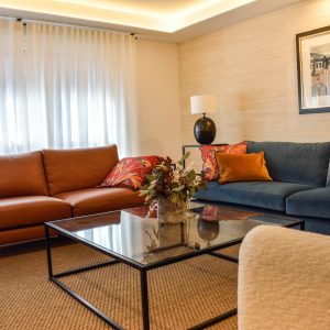 mobiliario moderno para salón en Zaragoza sofá azul y marrón, cortinas de lino blanco